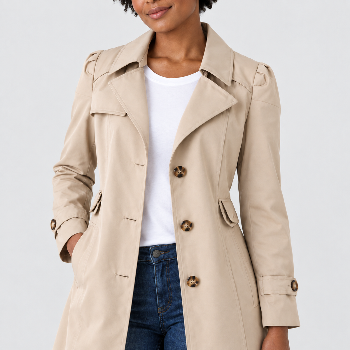 Close-up of tailored coat with notched lapels and cuff tabs, showing texture and fastening details