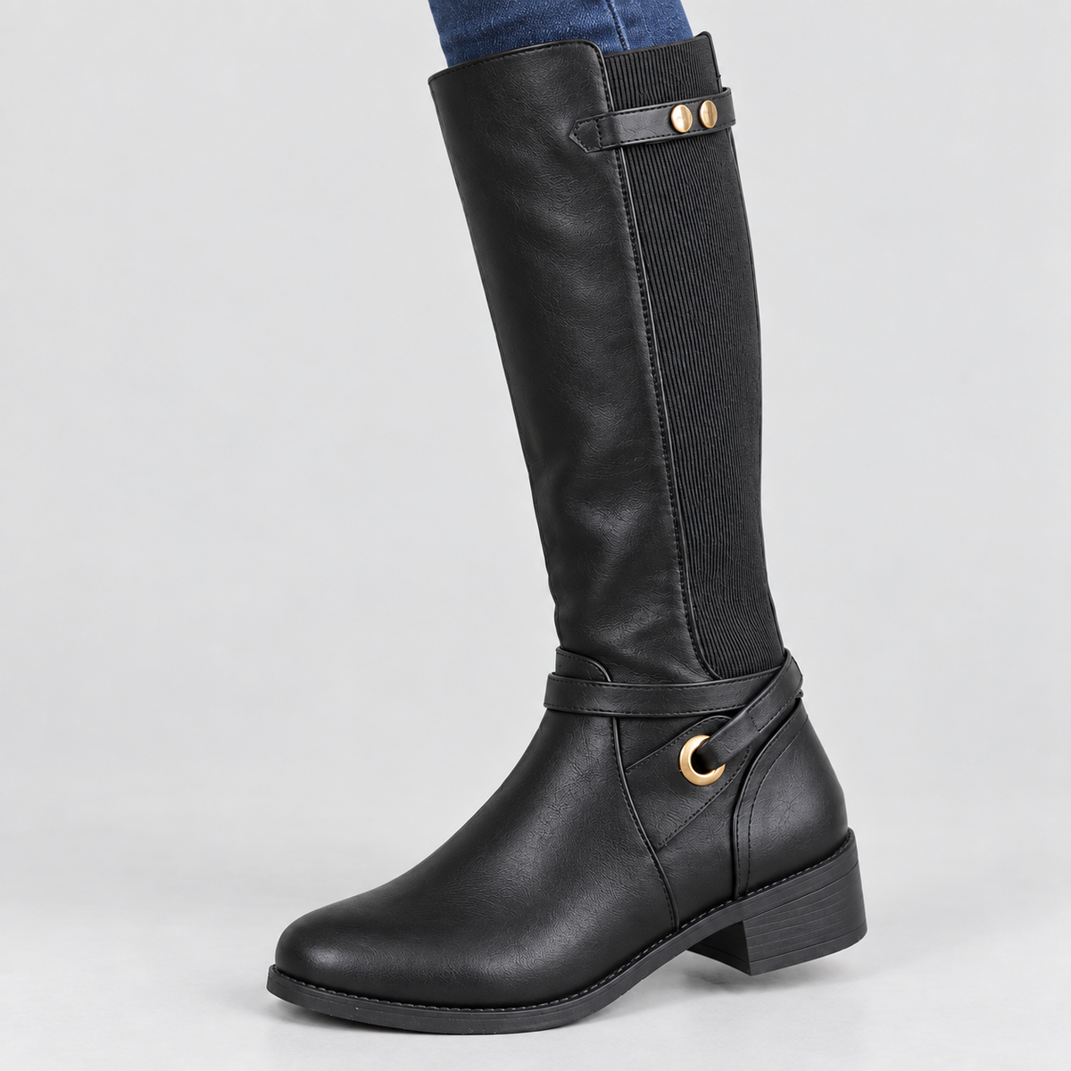 Close-up of tall riding boots with stretch panel and ankle ring, showing texture and fastening details